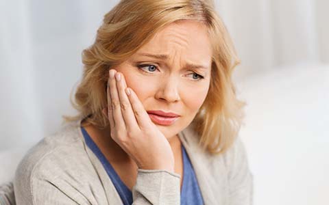 Pained woman who needs to visit her Corte Madera emergency dentist