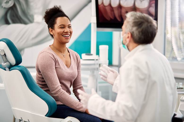 dentist placing a veneer in a patient’s smile