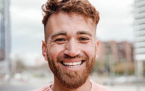 Man in pink sweater smiling with dental bridge in Corte Madera, CA