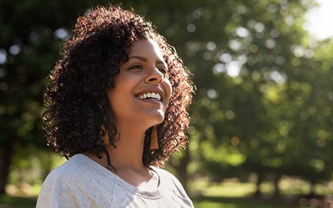 Woman outside smiling with dental bridge in Corte Madera, CA