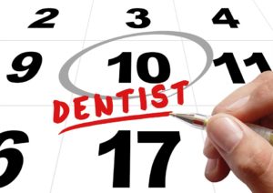 hand circling the word “dentist” on calendar