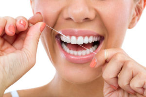 person flossing to prevent health issues