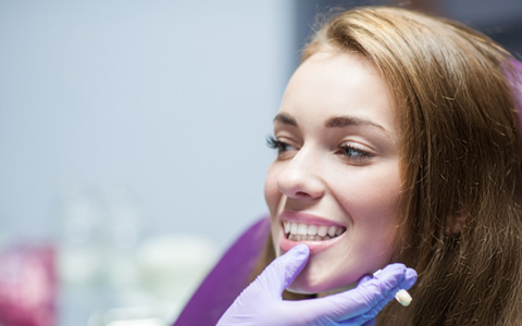 A dentist assessing a woman for dental crowns