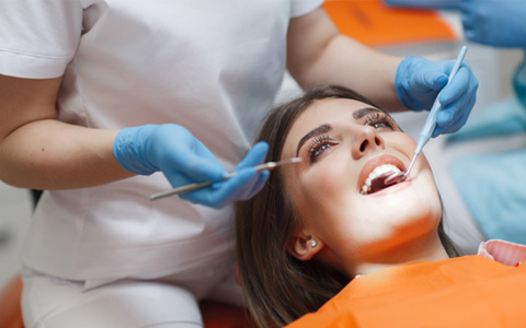 dentist looking at patient’s mouth 