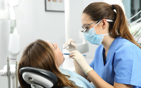 dentist working on patient’s mouth  